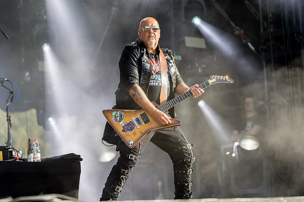 Ricky Wilde striking a cyberpunk rock pose with his guitar.