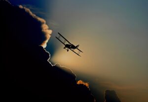 Speed of time: A light single-engine plane gliding above a mass of dark clouds.