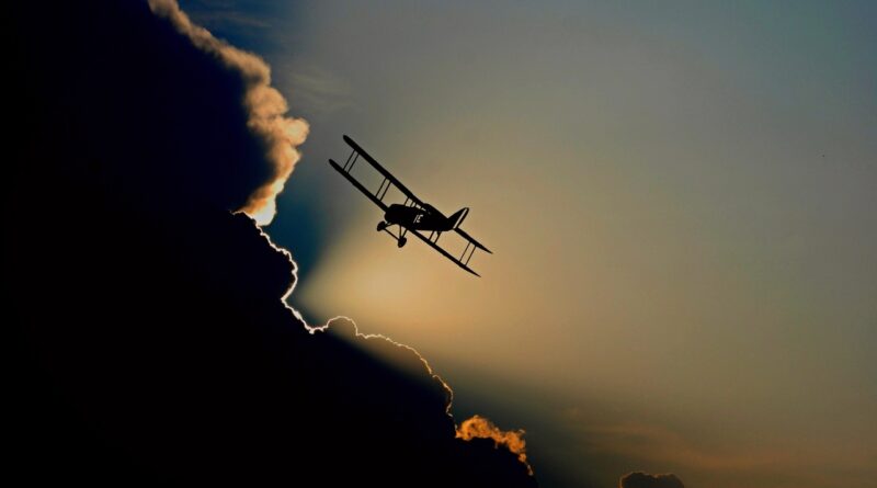 Speed of time: A light single-engine plane gliding above a mass of dark clouds.